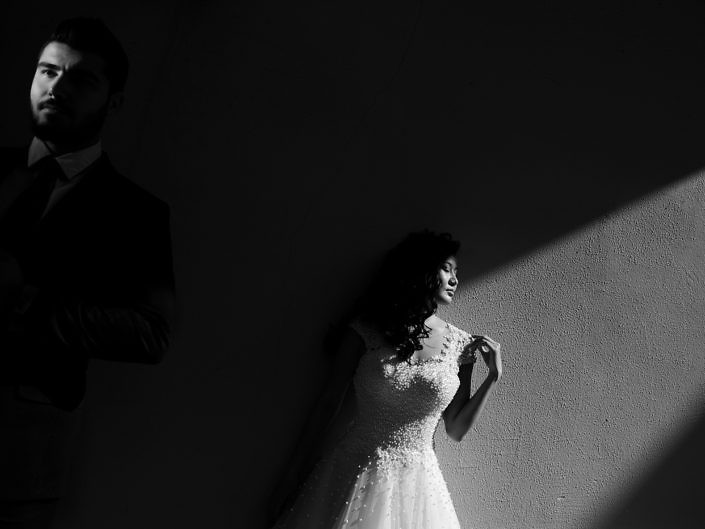 Mireasa într-o rază de lumină, lângă mire, fotografie întunecată