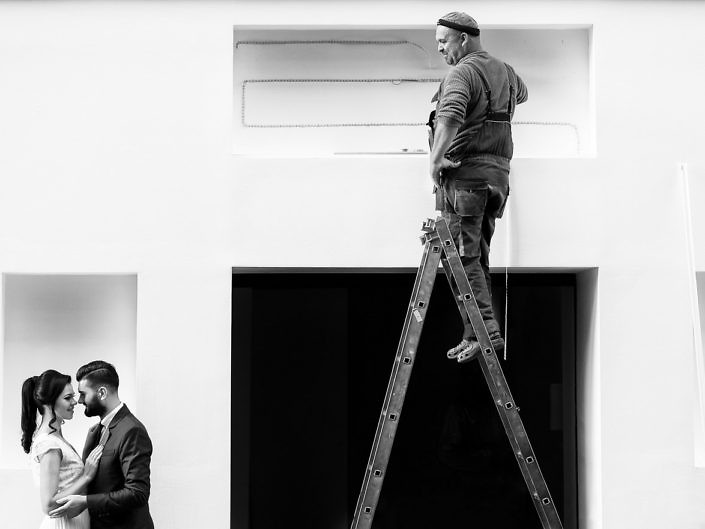 Mirii într-o galerie albă, cu un muncitor pe scară, alb-negru