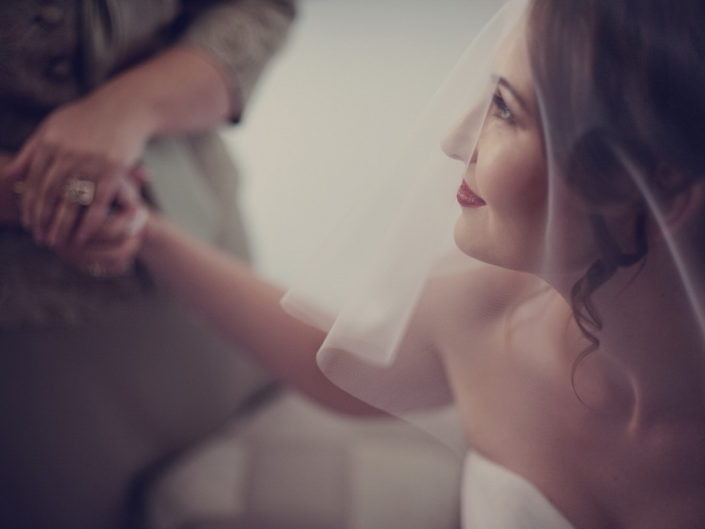 Mâinile mirilor și mireasa de profil, portret de nuntă în tonuri calde