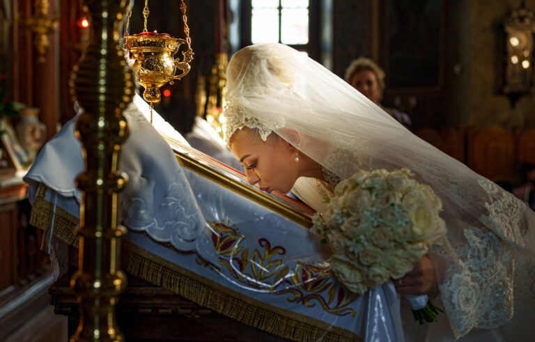 Mireasa sărutând icoana în timpul cununiei religioase