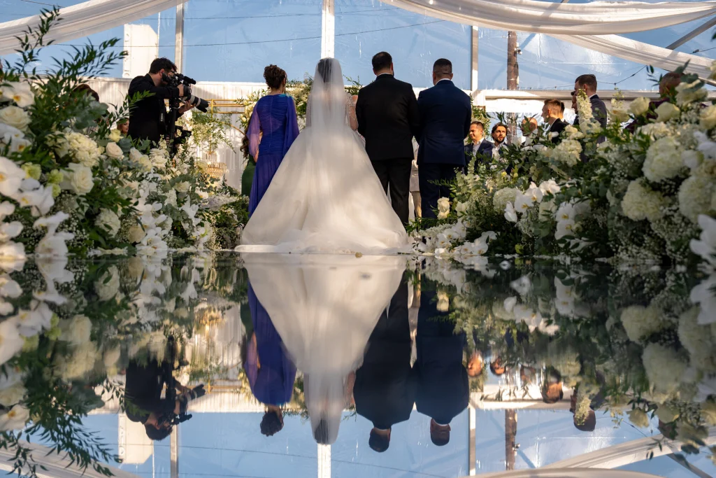 Mireasa pe culoarul-oglindă din cortul Diplomatic Mamaia, cu reflexia rochiei și a cerului