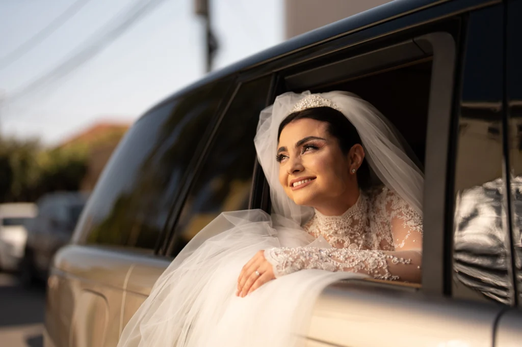 Mireasa privește pe geamul mașinii, în lumina după-amiezii, în drum spre nuntă