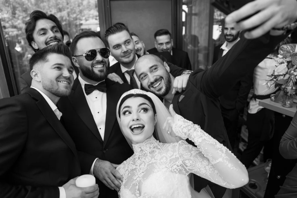Fotografie alb-negru cu mireasa surprinsă, înconjurată de mire și prietenii lui