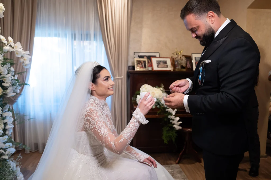 Mirele îi dă miresei buchetul de orhidee albe la luarea miresei